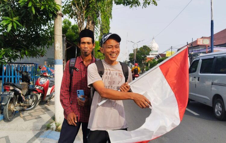 Anas dan Muhab semangat membawa Bendera Merah Putih di awal ekspedisi jalan kaki ke Tanah Suci Sabtu (1/2/2025). (foto/ist)